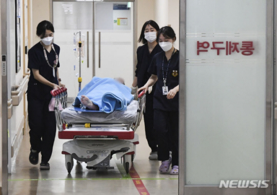 전공의들의 집단 사직으로 의료대란이 가시화하며 정부가 군병원 12곳 응급실을 민간인에게 개방한 20일 오후 의료진들이 경기도 성남시 국군수도병원 응급실에서 민간인 환자를 옮기고 있다. 뉴시스