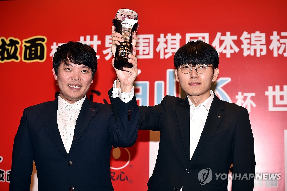 (서울=연합뉴스) 신진서(오른쪽) 9단이 23일 중국 상하이에서 열린 제25회 농심신라면배 세계바둑최강전 3라운드 최종 14국에서 중국의 마지막 주자 구쯔하오 9단에게 불계승 후 열린 시상식에서 홍민표 감독과 함께 트로피를 들어 보이고 있다. 2024.2.23 [한국기원 제공. 재판매 및 DB 금지]