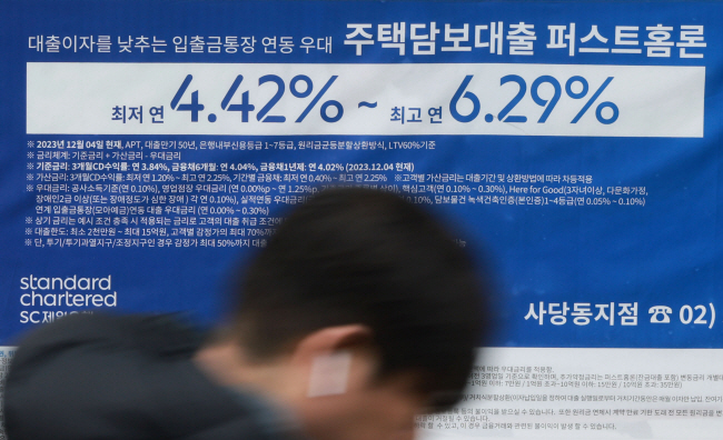 26일부터 주택담보대출에 ‘스트레스 총부채원리금상환비율(DSR)’이 적용돼 대출한도가 종전보다 줄어들 것으로 예상되는 가운데, 한 시민이 지난 25일 서울 시내 한 은행에 걸린 주택담보대출 관련 광고판 앞을 지나치고 있다. 연합뉴스