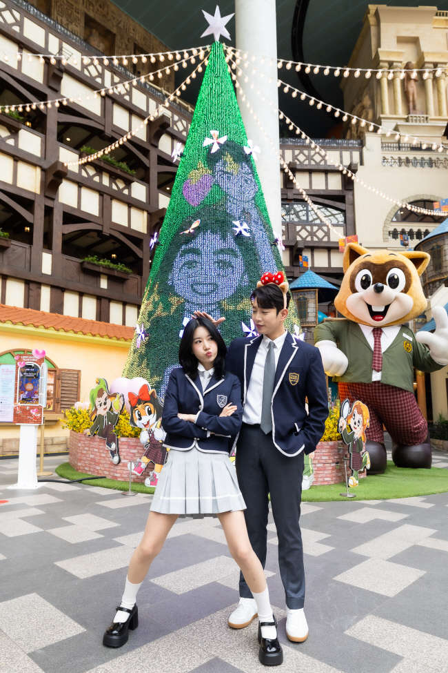 롯데월드가 학원·로맨스 웹툰과 협업한 신규 봄 축제 ‘애프터 스쿨 레슨’의 주 무대 드림캐슬 포토존. 관람객들이 교복을 빌려 입고 웹툰 속 주인공이 된 것처럼 사진 촬영을 한다.