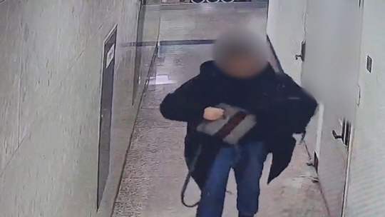 사우나를 돌며 수천만 원 상당을 훔친 30대 남성이 시흥시 한 사우나에서 훔친 가방을 외투 안에 숨기는 모습. 수원서부경찰서 제공