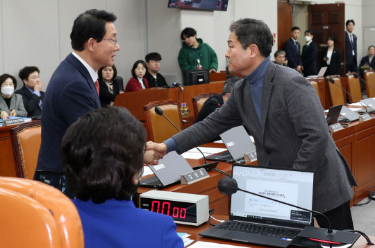 김상훈(왼쪽) 국민의힘, 김영배 더불어민주당 국회 정치개혁특별위원회 간사가 29일 오후 서울 여의도 국회에서 열린 전체회의에서 인사를 나누고 있다. 뉴시스