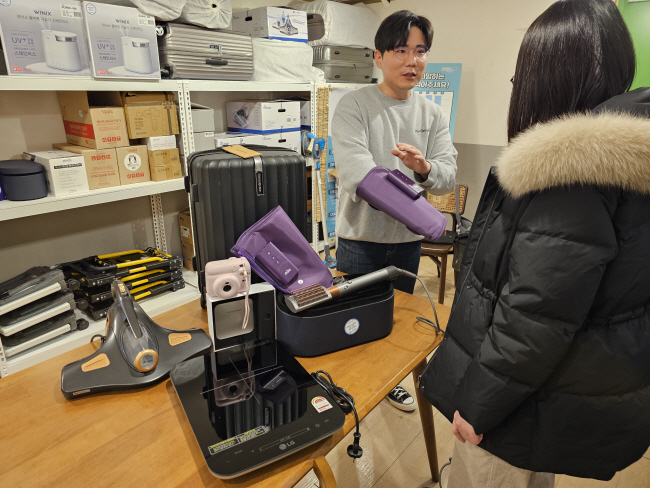 지난달 27일 서울 성북구 동선동 ‘청년공간 동선이음’에 마련된 1인 가구 물품대여 서비스 물품 보관소에서 성북구청 직원이 대여 물품을 수령하기 위해 찾은 1인 가구 청년에게 종아리 마사지기 사용법을 설명하고 있다. 성북구청 제공
