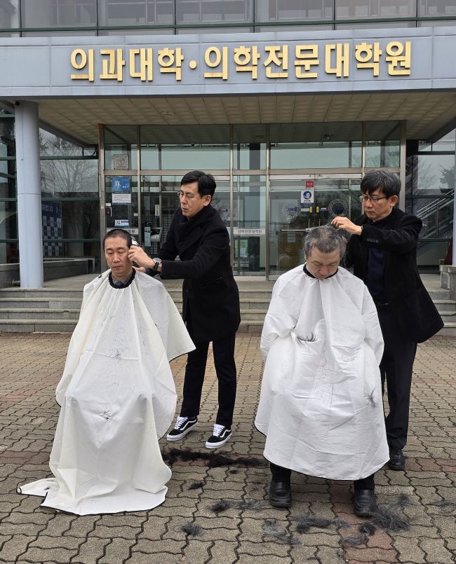 의대를 보유한 전국의 40개 대학이 모두 의대 증원을 신청한 이날 오전 강원대 의대 앞에서 의대 교수들이 대학 측의 증원 방침에 반발하는 삭발식을 열고 있다. 연합뉴스