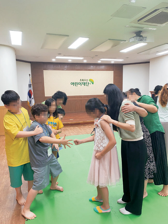지난해 7월 초록우산 대구종합사회복지관에서 진행된 다문화가족 관계증진 프로그램 ‘핑퐁패밀리’에 참여한 아이들과 엄마들이 가위바위보 기차놀이를 즐기고 있다. 초록우산 제공