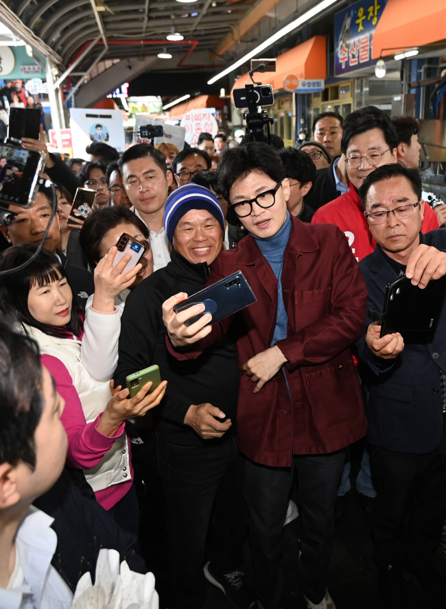 한동훈(앞줄 오른쪽 두 번째) 국민의힘 비상대책위원장이 15일 오전 전남 순천시 전통시장인 웃장을 방문해 시민들과 셀카를 찍고 있다.  윤성호 기자
