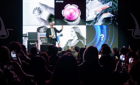 다이슨 창업자인 제임스 다이슨 경이 18일 서울 성동구 복합문화공간 ‘XYZ’에서 열린 차세대 기술 소개 행사에 등장해 신제품 ‘슈퍼소닉 뉴럴 헤어드라이어’를 소개하고 있다. 다이슨 제공