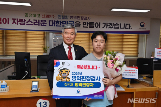 2024년도 첫 병역판정검사가 시작된 지난 2월1일 서울 영등포구 서울지방병무청 제1병역판정검사장에서 입영대상자인 이지환 씨가 현역대상 판정을 받자 이기식 병무청장이 꽃다발을 전달하고 있다. 사진공동취재단