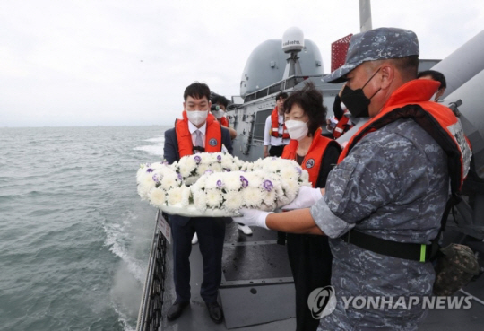 제2연평해전 승전 20주년 기념식이 열린 2022년 6월 29일 경기도 서해 해상에서 고 윤영하 소령의 동생 윤영민 씨와 어머니 황덕희 씨가 유도탄고속함 ‘윤영하함’을 타고 해상 헌화를 하고 있다. 사진공동취재단