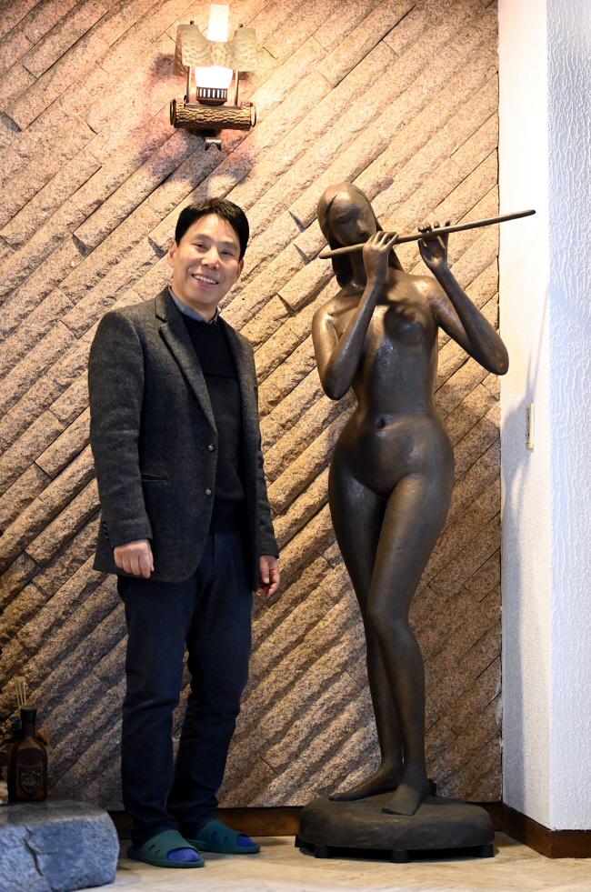 신문선 와우갤러리 명예관장이 박영선 작가의 조각과 포즈를 취했다. 그는 “1990년대에 이걸 샀을 때, 아내가 값을 물어와 0자 하나 떼고 말했다”며 “넉넉하지 않음에도 작품 수집을 허락해준 아내에게 늘 고맙다”고 했다. 박윤슬 기자