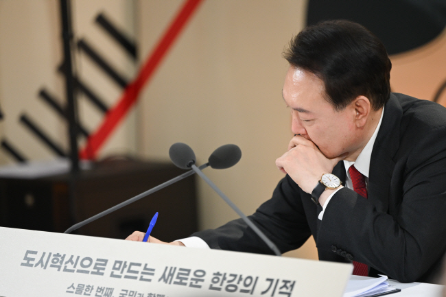 윤석열 대통령이 19일 ‘도시혁신으로 만드는 새로운 한강의 기적’을 주제로 서울 문래예술공장에서 열린 민생토론회에 참석해 시민들의 발언을 들으면서 메모를 하고 있다. 연합뉴스