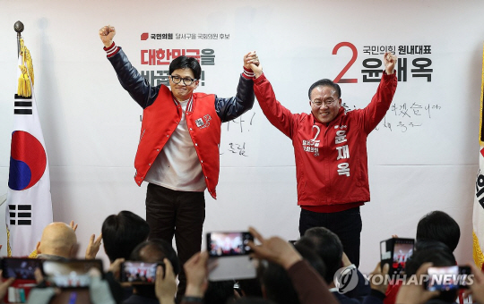 한동훈(왼쪽) 국민의힘 비상대책위원장 겸 총괄선거대책위원장이 21일 오후 대구 달서구 윤재옥 대구 달서을 후보 선거사무실 개소식을 찾아 윤재옥 원내대표 겸 공동선거대책위원장과 함꼐 손을 들어 인사하고 있다. 연합뉴스