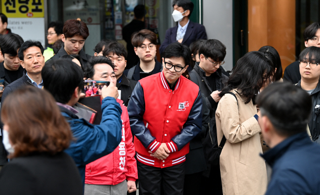 한동훈(가운데) 국민의힘 비상대책위원장 겸 총괄선거대책위원장이 25일 오전 서울 영등포구 여의도역 5번 출구에서 영등포을에 출마한 박용찬(한 위원장 왼쪽) 후보와 출근길 거리인사를 하고 있다.  윤성호 기자