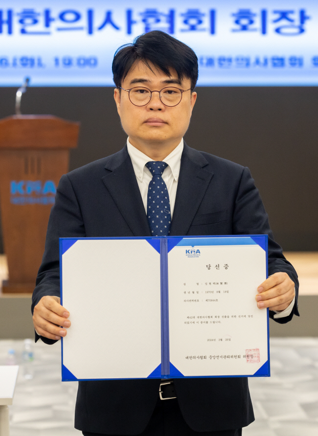 임현택 신임 대한의사협회 회장이 26일 서울 용산구 의협에서 열린 제42대 의협 회장 선거 결선투표 직후 당선증을 들어 보이고 있다.   연합뉴스