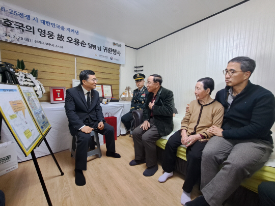 이근원(왼쪽) 국방부유해발굴감식단장)이 29일 경기도 부천시 고 오용순 일병의 유가족 자택을 찾아 ‘호국의 영웅 귀환 행사’를 갖고, 유가족에게 고인의 참전 과정과 유해발굴 경과를 설명하고 있다. 국방부 제공