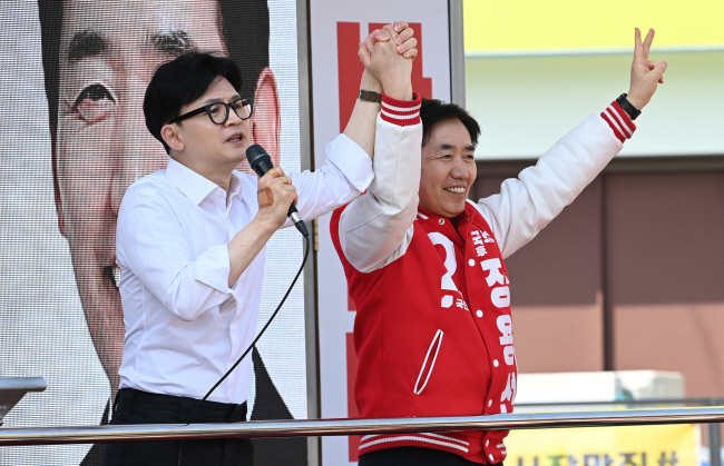 한동훈(왼쪽) 국민의힘 비상대책위원장이 2일 오전 충남 당진시 당진전통시장에서 정용선 후보의 손을 들어 올리며 지지를 호소하고 있다.  윤성호 기자