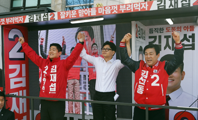 한동훈(가운데) 국민의힘 비상대책위원장이 4일 오전 서울 도봉구 쌍문역 인근에서 김재섭 도봉갑·김선동 도봉을 후보의 손을 들어 올리며 지지를 호소하고 있다. 박윤슬 기자