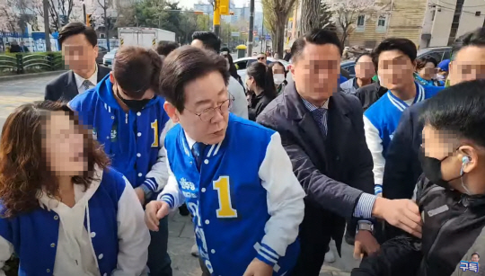 이재명 더불어민주당 대표가 7일 오전 인천 계양구에서 유세를 하다가 행인이 뒤에서 부딪히자 깜짝 놀라 쳐다보고 있다. 유튜브 ‘이재명’ 채널 라이브 방송 캡처