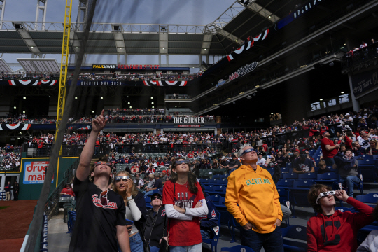 8일 미국 오하이오주 클리블랜드의 프로그레시브 필드에서 미국 프로야구 메이저리그 클리블랜드 가디언스와 시카고 화의트삭스의 경기에 앞서 관중들이 개기일식을 바라보고 있다. AP 뉴시스