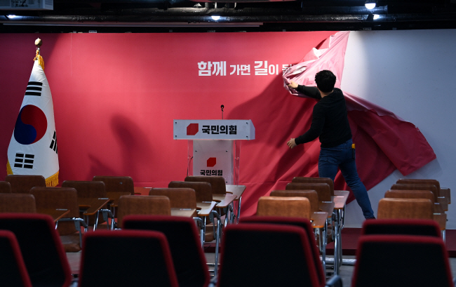 11일 오전 서울 여의도 국민의힘 중앙당사에서 당 관계자가 총선 기간 중 사용된 배경막을 교체하고 있다. 윤성호 기자