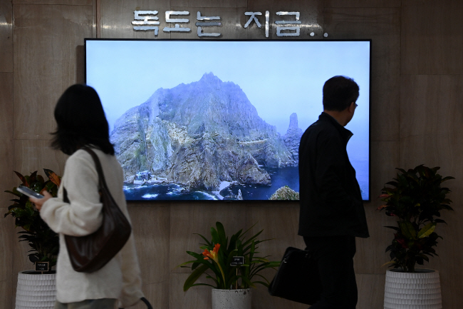 16일 오전 서울 종로구 정부서울청사 공무원들이 1층 로비에서 ‘독도는 지금’ 실시간 화면 영상을 쳐다보면서 출근하고 있다. 문호남 기자