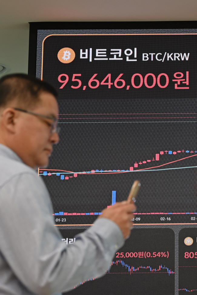 비트코인 가격이 중동 정세 불안, 미국 고금리 장기화 가능성 등 여파로 변동성이 커진 가운데, 한 시민이 17일 오전 서울 서초구 빗썸 고객센터 전광판 앞에서 비트코인 시세를 확인하고 있다. 백동현 기자