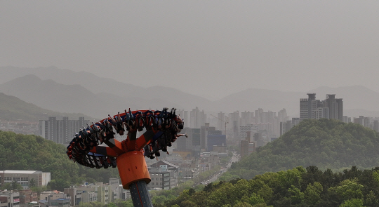 황사 영향으로 대구지역 미세먼지 농도가 ‘매우 나쁨’ 수준을 보인 17일 대구 달서구 이월드에서 시민들이 미세먼지로 뿌연 대구 도심 속에서 놀이기구를 타고 있다. 연합뉴스