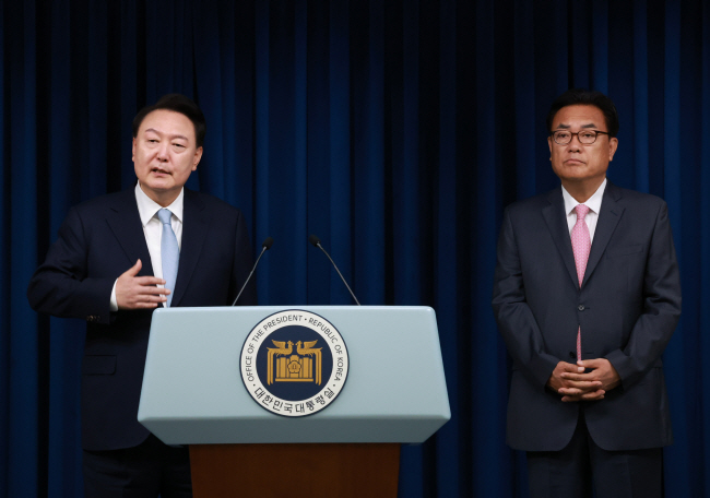 윤석열 대통령이 22일 오전 서울 용산 대통령실 청사에서 팔을 벌리면서 정진석 신임 대통령 비서실장을 취재진들에게 소개하고 있다.  연합뉴스