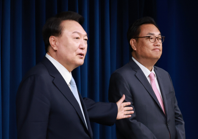윤석열 대통령이 22일 오전 서울 용산 대통령실 청사에서 팔을 벌리면서 정진석 신임 대통령 비서실장을 취재진들에게 소개하고 있다. 연합뉴스