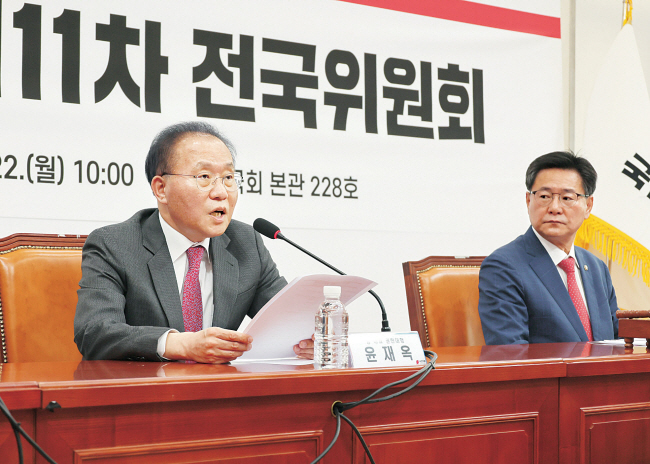 윤재옥(왼쪽) 국민의힘  당 대표 권한대행 겸 원내대표가 22일 오전 국회에서 비례대표 위성정당인 국민의미래와 흡수 합당 결의안을 의결하는 제11차 전국위원회에 참석해 발언하고 있다. 오른쪽은 이헌승 전국위의장.  연합뉴스