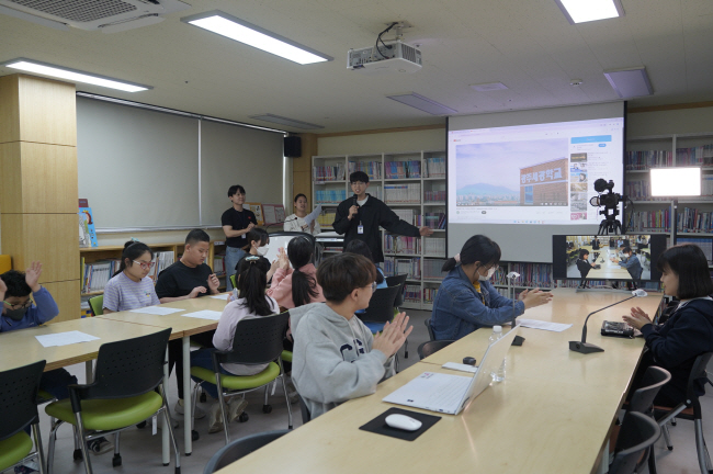 지난 19일 시각장애 특수학교 광주세광학교의 임병진(가운데) 교사가 마이크를 쥐고 방송반 학생들과 함께 아침방송 ‘보이는 라디오’ 사전 제작 활동을 하고 있다.  LG유플러스 제공