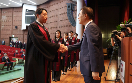 박성재(오른쪽) 법무부 장관이 1일 정부과천청사에서 열린 신임검사 임관식에서 신임 검사들과 악수하고 있다. 뉴시스