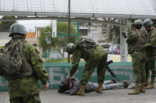 지난달 18일 에콰도르 키토에서 도로를 순찰하던 군인들이 한 남성을 검문하고 있다. AP 뉴시스