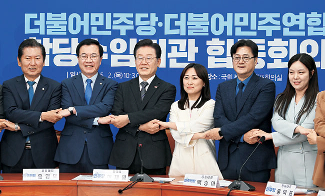 이재명(왼쪽 세 번째) 더불어민주당 대표가 2일 오전 국회에서 열린 민주당의 비례대표 위성정당인 더불어민주연합과의 합당수임기관 합동회의에서 백승아(〃네 번째) 민주연합 공동대표 등과 함께 손을 맞잡고 기념사진을 촬영하고 있다.  곽성호 기자