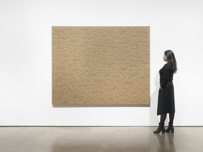 서울 종로구 갤러리현대에서 열리고 있는 전시 ‘영롱함을 넘어서’에서 김창열의 1979년 작 ‘물방울 ENS 203’을 한 관람객이 감상하고 있다. 캔버스에 유채, 182×227.5㎝.  갤러리현대 제공