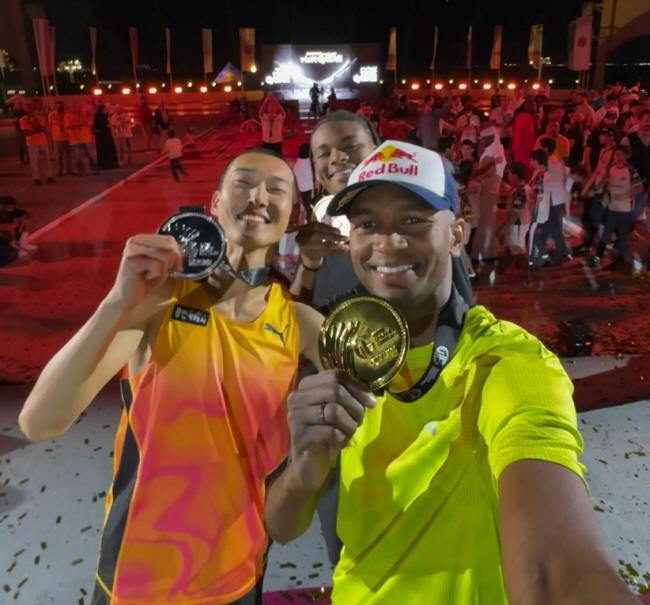 우상혁(아래 왼쪽)과 무타즈 에사 바르심(〃오른쪽), 주본 해리슨이 9일 밤(한국시간) 카타르 도하의 카타라 원형극장에서 왓 그래비티 챌린지 메달을 든 채 활짝 웃고 있다.  왓 그래비티 챌린지 SNS