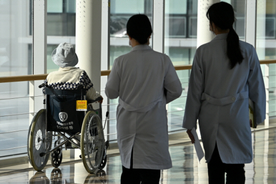 전국의과대학교수 비상대책위원회가 휴진을 선언한 10일 오전 서울 서대문구 세브란스병원에서 환자 옆으로 의료진이 지나가고 있다. 백동현 기자