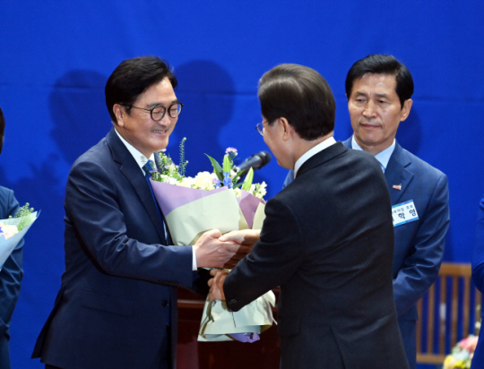 16일 오전 서울 여의도 국회 의원회관에서 열린 더불어민주당 당선인 총회에서 제22대 전반기 국회의장 당내 경선에서 승리한 우원식(왼쪽) 후보가 이재명(가운데) 당 대표로부터 축하 꽃다발을 받고 있다. 박윤슬 기자