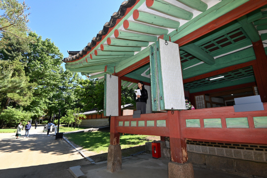16일 오전 서울 종로구 종묘 향대청 옆 망묘루에서 한 시민이 바깥 풍경을 바라보고 있다. 망묘루는 종묘를 바라보는 누마루 집이라는 뜻의 건물이다. 6월 30일까지 특별 개방된다. 문호남 기자