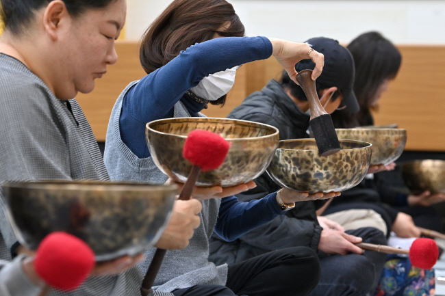 강원 홍천군 내면 명개리를 찾은 관광객들이 싱잉볼을 들고 스틱을 이용해 소리를 내고 있다.   백동현 기자