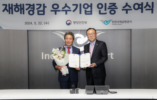 지난 22일 인천공항 통합운영센터 회의실에서 열린 ‘재해경감 우수기업 인증서 수여식’에서 인천국제공항공사 이학재 (왼쪽) 사장이 인증서를 전달받은 후 기념촬영 하고 있다. 인천국제공항공사 제공