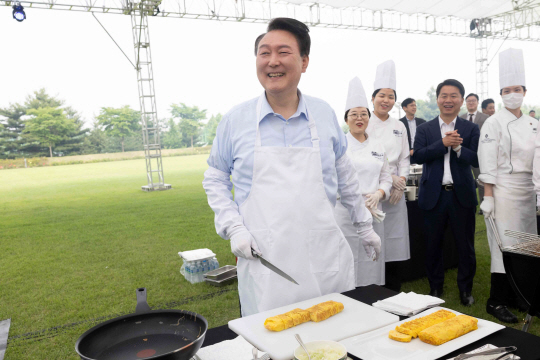 윤석열 대통령이 24일 서울 용산 대통령실 잔디마당에서 열린 출입기자단 초청 만찬 간담회에 참석해 계란말이를 조리하고 있다. 대통령실 제공