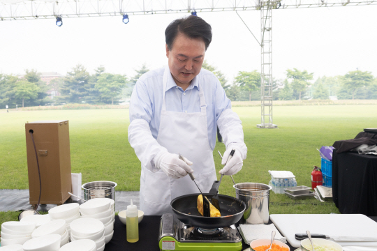 윤석열 대통령이 24일 서울 용산 대통령실 청사 잔디마당에서 열린 ‘대통령의 저녁 초대’ 출입기자단 초청 만찬 간담회에서 계란말이를 만들고 있다. 대통령실 제공