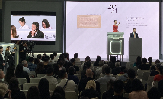 28일 홍콩 컨벤션센터 세일즈룸에서 열린 크리스티 홍콩 상반기 경매. 벨린(왼쪽 상단 화면) 사장이 한국 작가 이성자의 1962년작 ‘그림자 없는 산’의 전화 대리 입찰에 참여하고 있다. 박동미 기자