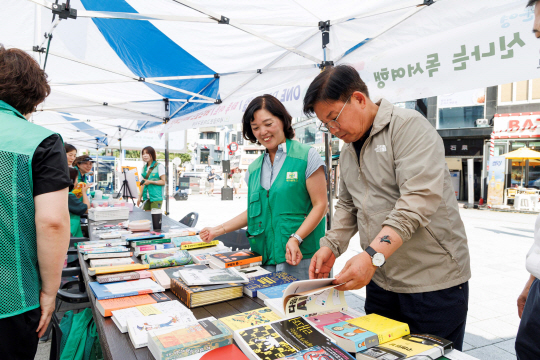 지난해 새마을문고 주관‘책사랑 알뜰도서 교환전’ 행사에 참석해 책을 살펴보는 박강수 마포구청장. 마포구청 제공
