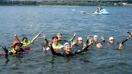 오세훈(가운데) 서울시장이 1일 뚝섬한강공원을 찾아 ‘제1회 쉬엄쉬엄 한강 3종 축제’ 초급자 코스인 수영 300m에 앞서 참가 시민들과 두팔을 들고 완주를 다짐하며 기념 촬영하고 있다. 서울시 제공