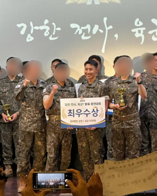 4일 서울 용산 전쟁기념관에서 열린 ‘강한 전사, 육군! 발표 경연대회’에서 군 경험담을 발표해 최우수상을 받은 방탄소년단(BTS) 제이홉이 수상 후 전우들과 함께 기뻐하고 있다. 제이홉 홈페이지 캡처