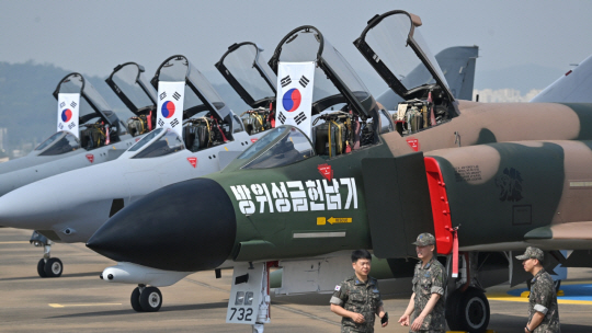 오는 7일 F-4E 팬텀 공식 퇴역식을 앞두고 미디어데이가 열린 5일 오전 경기 수원기지에 1969년 당시  팬텀 초기형 F-4D 방위성금헌납기를 재현하기 위해 앞부분 검정, 몸체 녹색 도색을 해 선보이고 있다. 그 뒤로 팬텀 파생형인  RF-4C,  F-4E 등 한국에 도입된 팬텀 기종이 전시돼 있다. 이날  유럽 등 외국에서 온 100여명의 취재진과 팬텀 마니아들이 수원기지를 찾았다. 백동현 기자