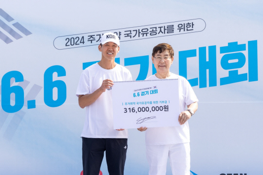 기부금 전달하는 가수 션(사진 왼쪽)