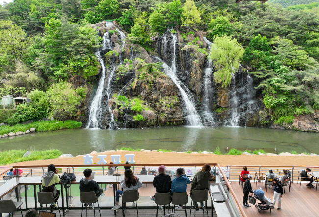 SNS 등을 통해 입소문을 타고 외국인 관광객이 끊이지 않는 서울 서대문구 홍제폭포 앞 카페에서 방문객들이 폭포를 바라보고 있다. 서대문구청 제공